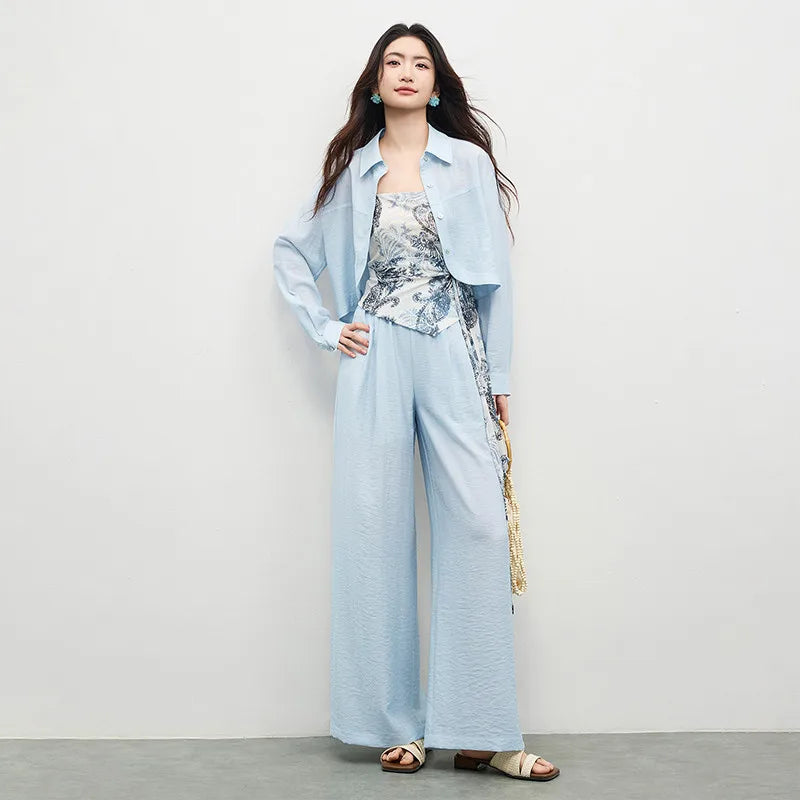 Three-piece set in Lapis Shimmer. Noble lyocell and linen blend. Cropped shirt with rounded hem, draped wrap top with Cashew Flower texture, and wide-leg trousers. — From Borcelleclothes.