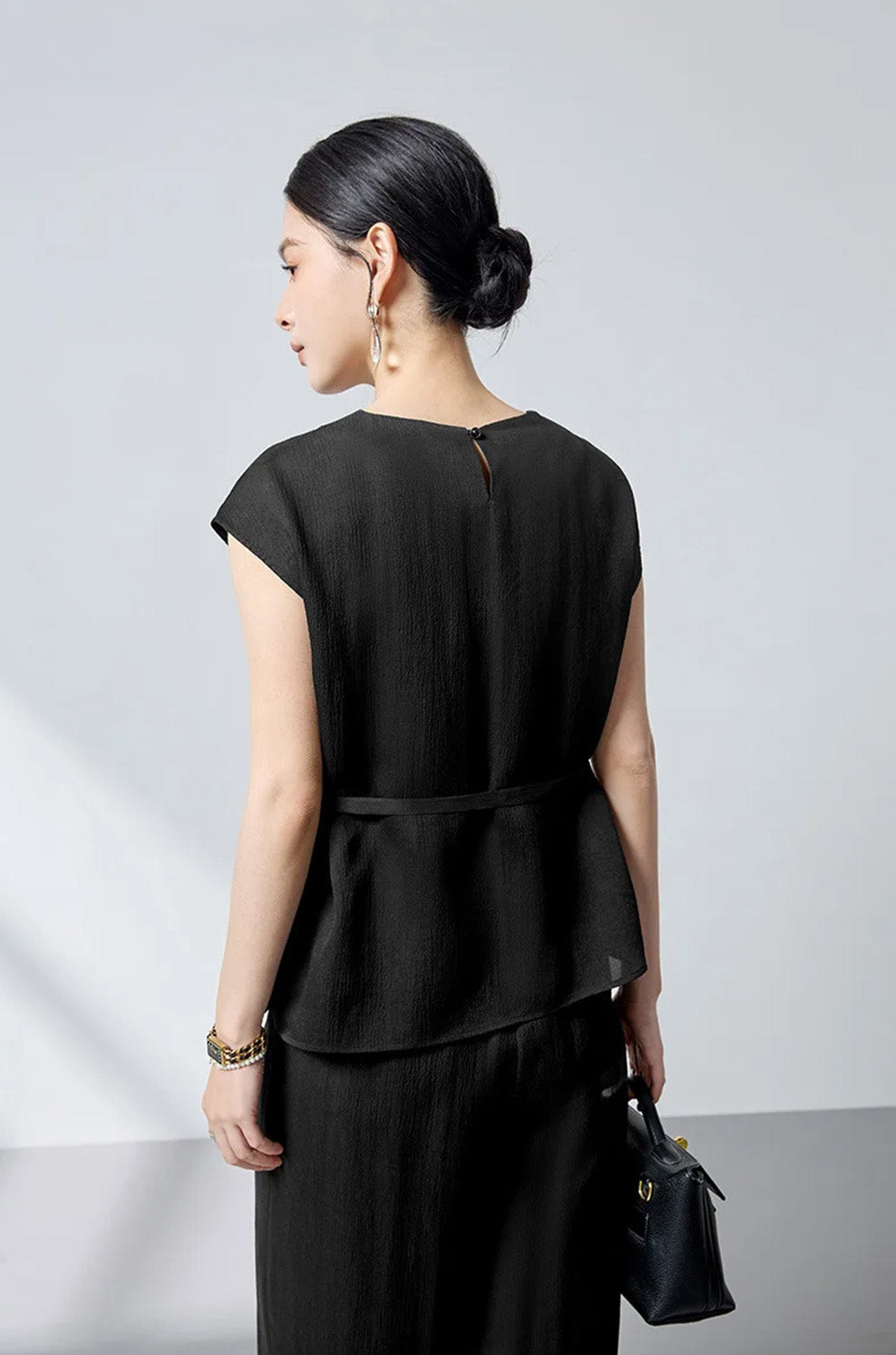 Back view of the women's defined waist mulberry silk blouse in Queen of Spades on model — From Borcelleclothes.
