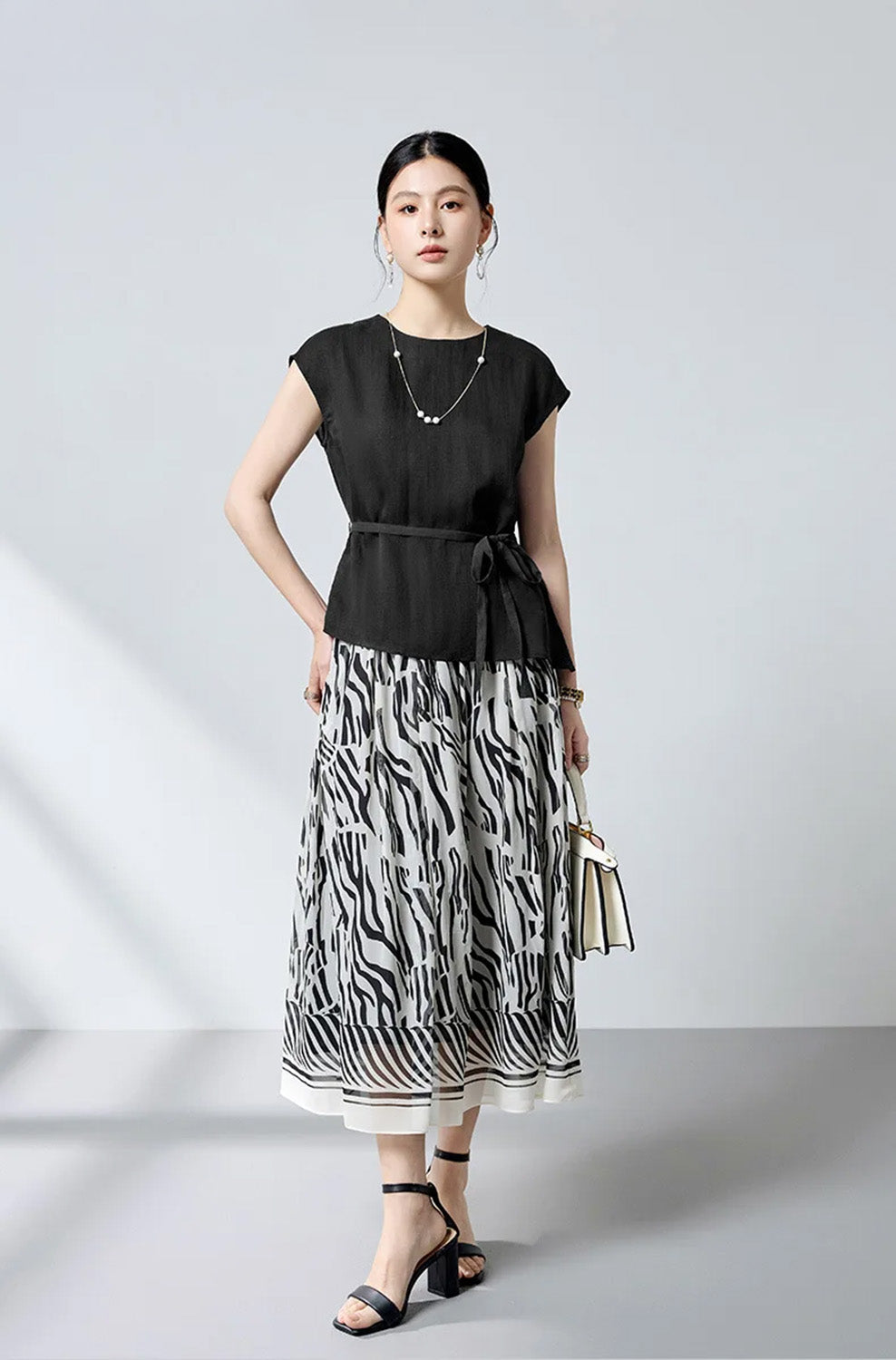 Full-length view of model wearing the defined waist silk blouse with hand on hip — From Borcelleclothes.