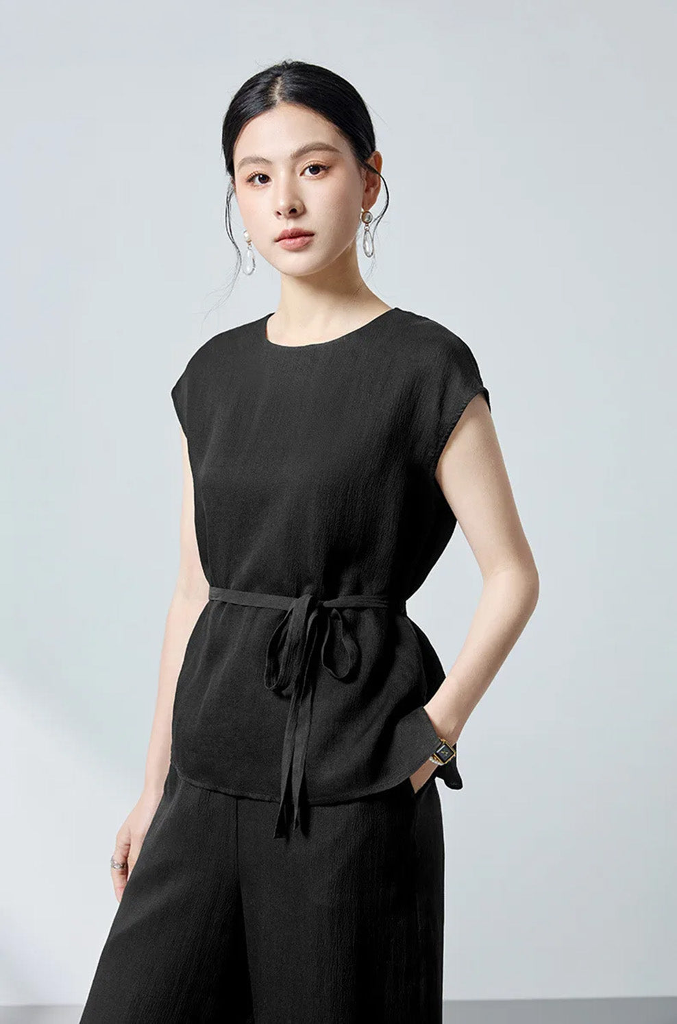 Model wearing the Queen of Spades silk blouse looking straight with hand in pocket — From Borcelleclothes.