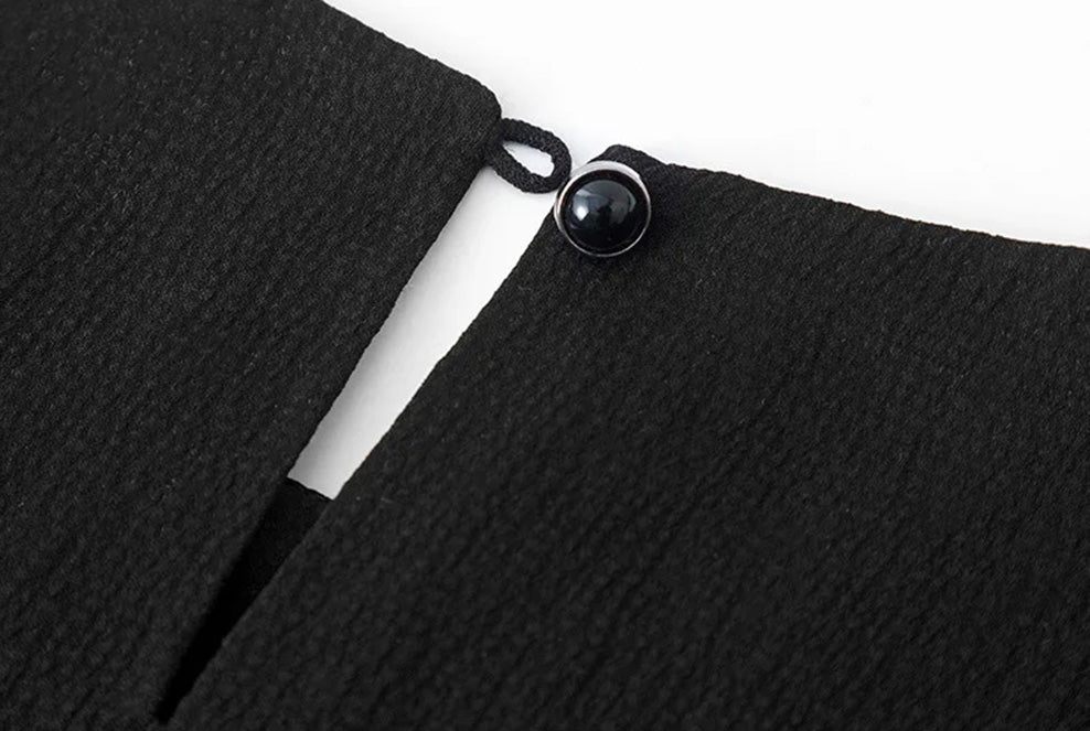 Back slit detail with unfastened cabochon button on the Queen of Spades silk blouse — From Borcelleclothes.