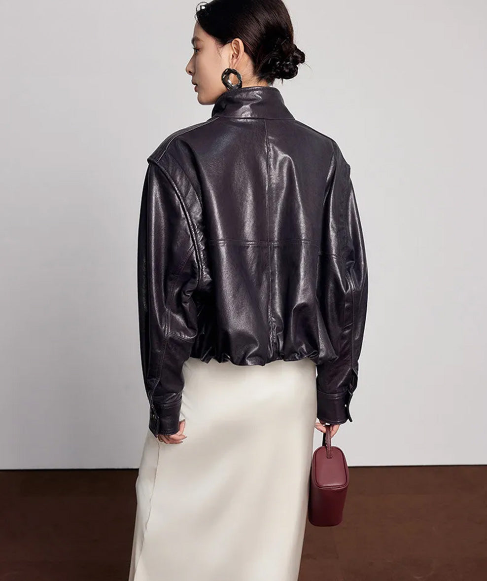 Rear view of the domed-hem sheepskin jacket paired with a small handbag — From Borcelleclothes.
