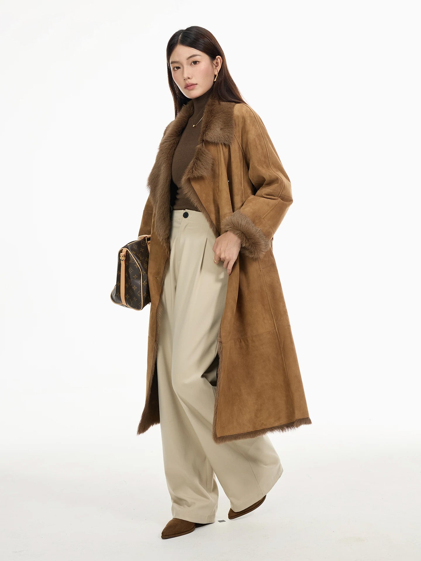 Side view of the Golden Mist double-breasted goatskin coat in motion, showing fluid hemline and exposed fur trim. — From Borcelleclothes.