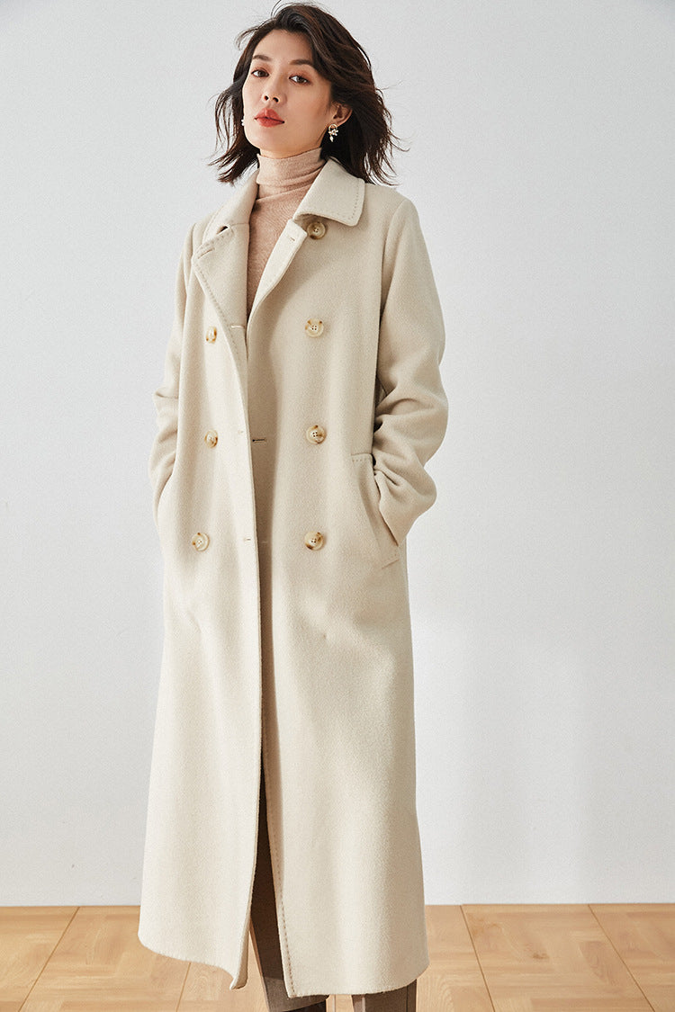 Double-breasted Moment of Promise coat in beige, model with hands in diagonal pockets — From Borcelleclothes.