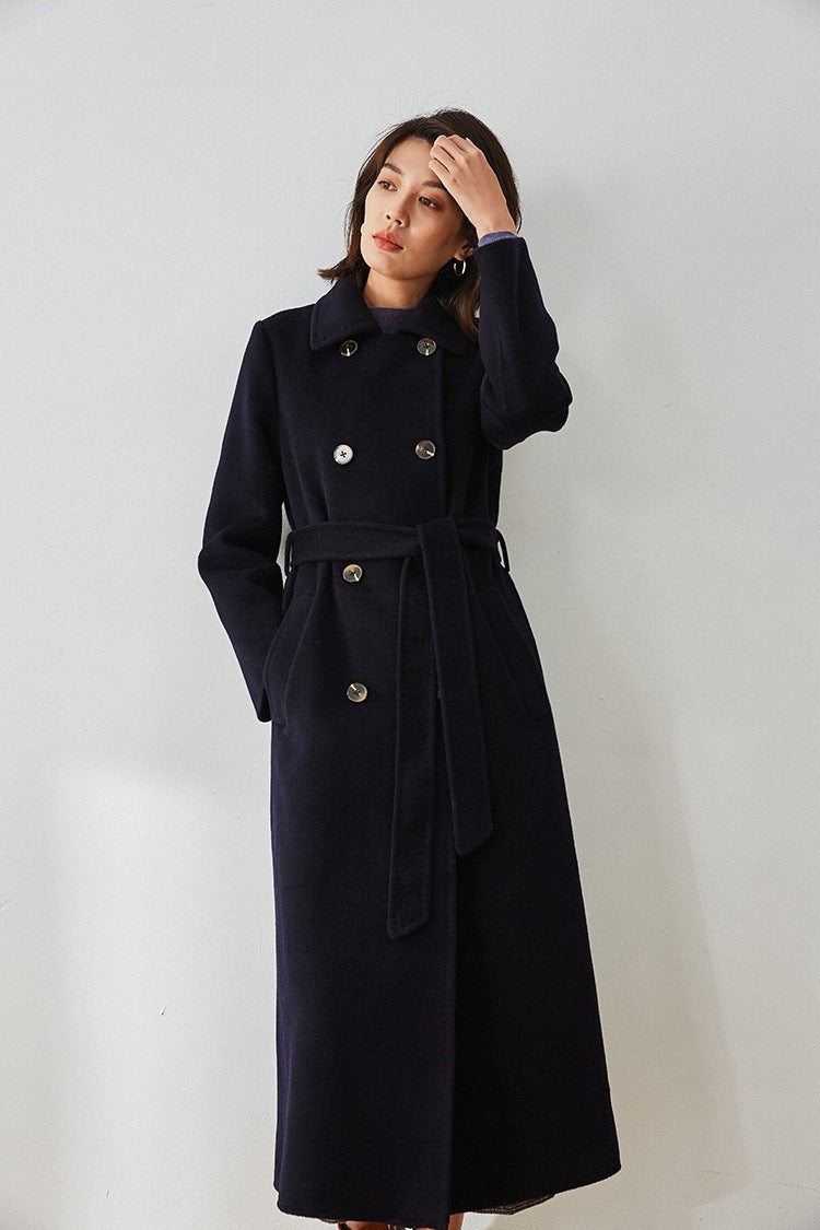 Model in Written in Ink navy coat adjusting hair, showcasing the pointed collar — From Borcelleclothes.