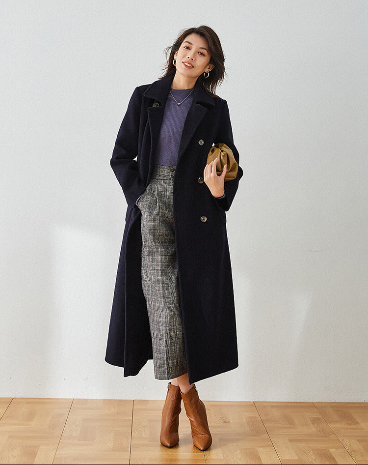 Written in Ink navy blue coat, model with hand in pants pocket showing the unfastened drape — From Borcelleclothes.