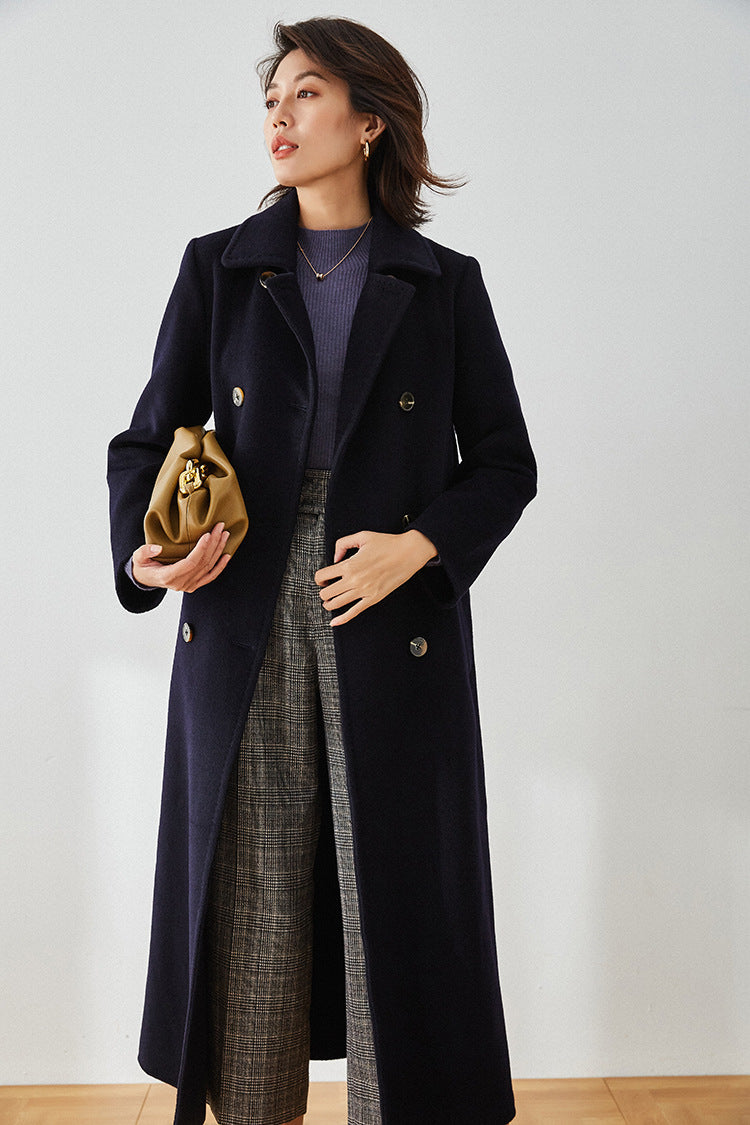 Written in Ink navy blue wool coat, model holding a bag — From Borcelleclothes.
