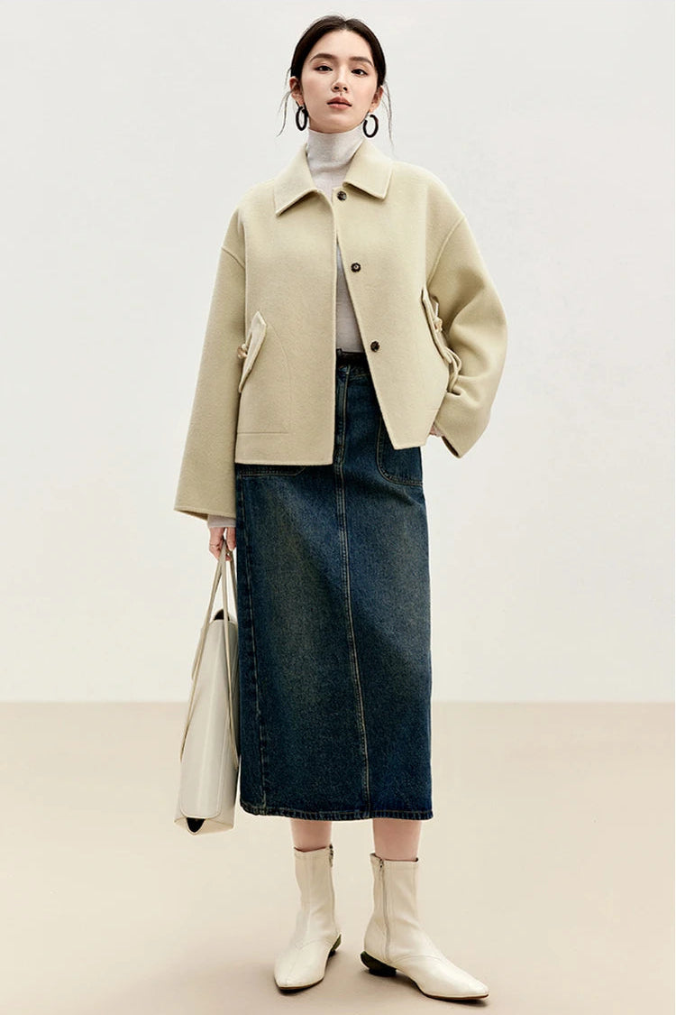 A woman in the Edelweiss Pollen yellow wool jacket with a hand on her hip, showcasing the calm natural tone — From Borcelleclothes.