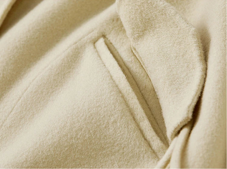 A detail shot of a woman's hand on the Edelweiss Pollen jacket pocket with a raised flap and toggle tassels — From Borcelleclothes.