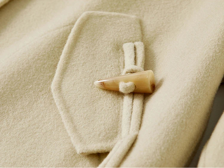A macro view of the artisanal bone toggle and wool loop on the Edelweiss Pollen jacket — From Borcelleclothes.