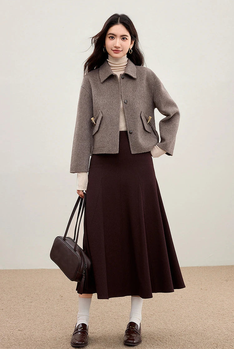 A woman wearing the Lost Summit jacket and holding a matching leather bag for a cohesive tonal look — From Borcelleclothes.