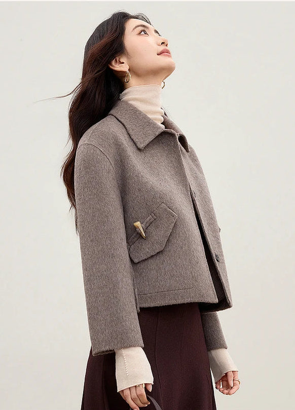 A woman looking up while wearing the Lost Summit grey jacket, capturing the feeling of freedom and altitude — From Borcelleclothes.