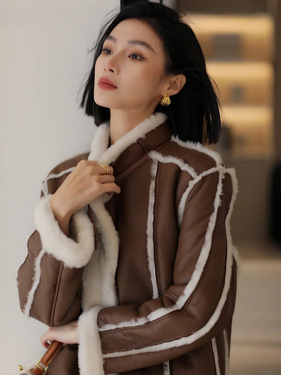 Model gathering the collar of the Drambuie Cocktail shearling coat close around her — From Borcelleclothes.