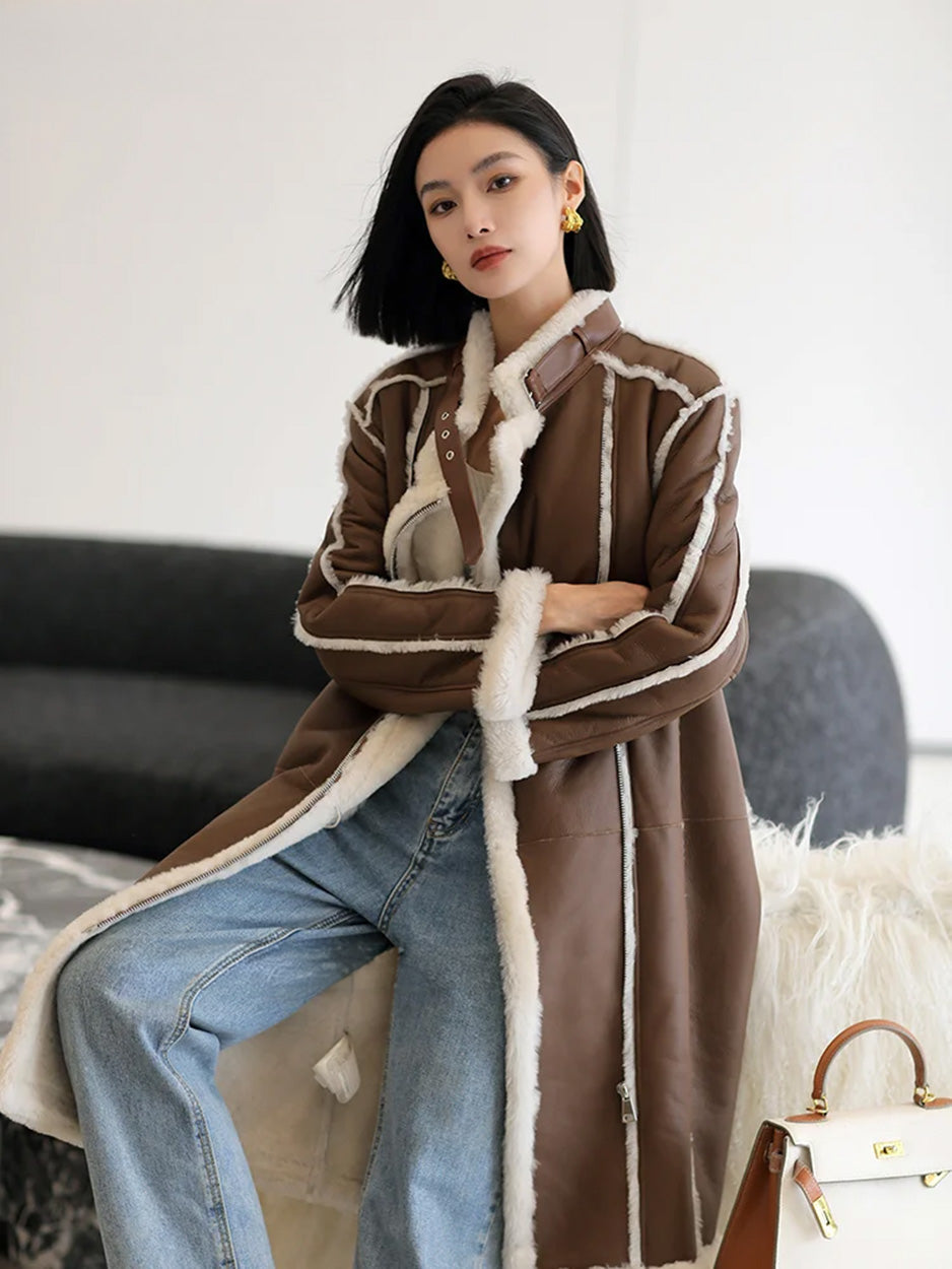 Model sitting on a sofa in the Drambuie Cocktail shearling coat, relaxed pose — From Borcelleclothes.