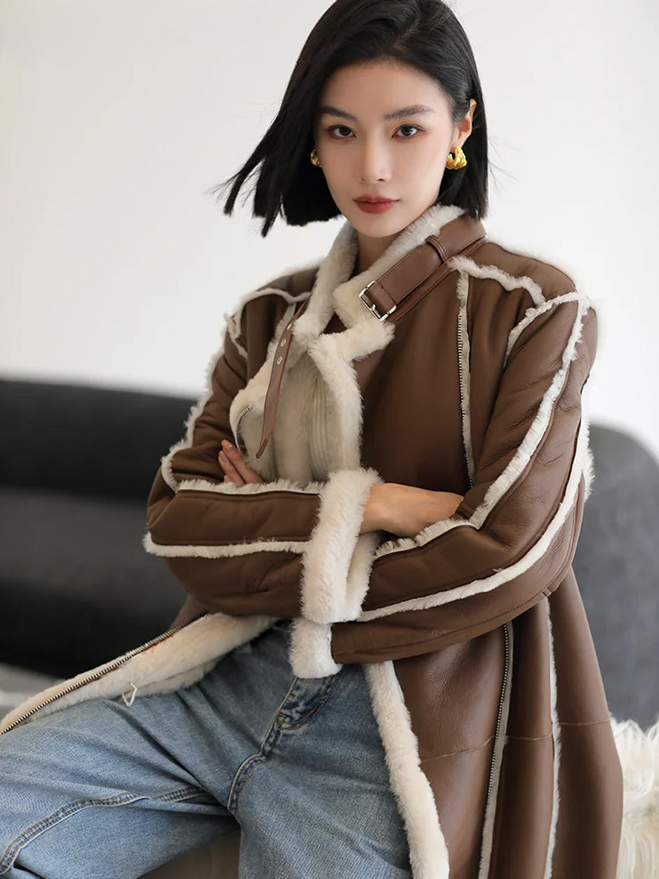 Seated model with arms crossed, wearing the Drambuie Cocktail shearling coat — From Borcelleclothes.
