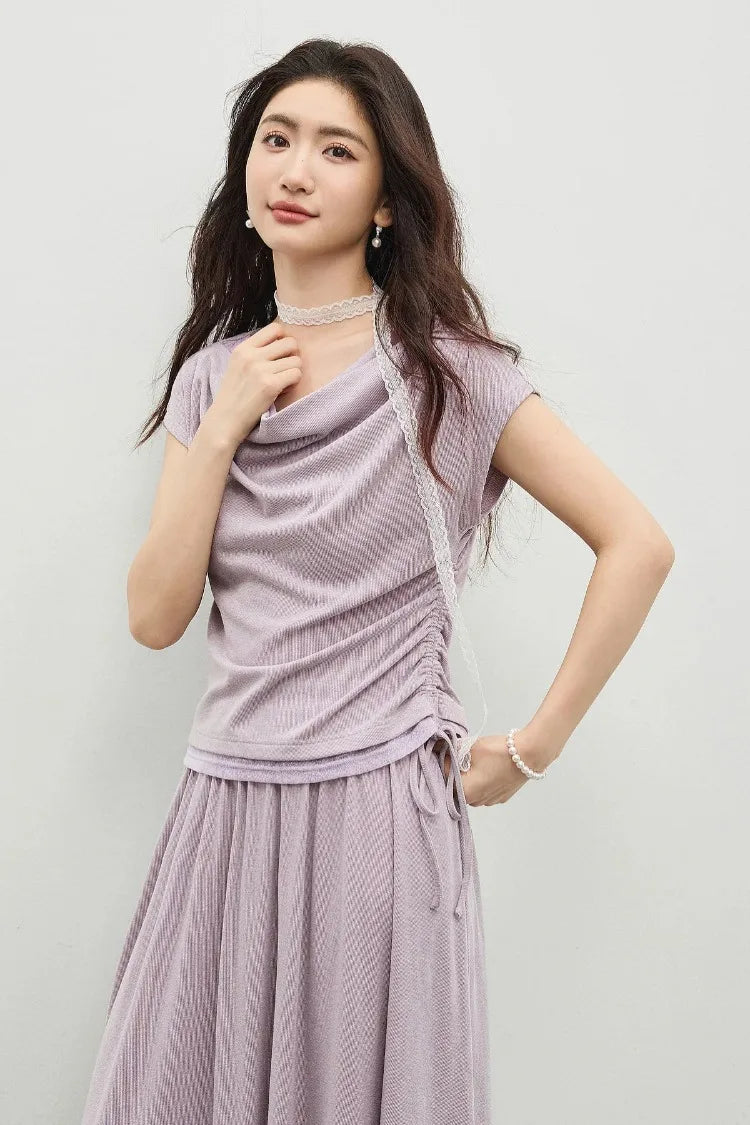 The intimacy of touch: model gently adjusting the soft cowl collar of the viscose top. — From Borcelleclothes.