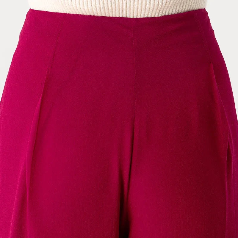 Upper back detail of Mulberry silk trousers in Raspberry Perspective featuring discreet knife pleats at the waist — From Borcelleclothes.