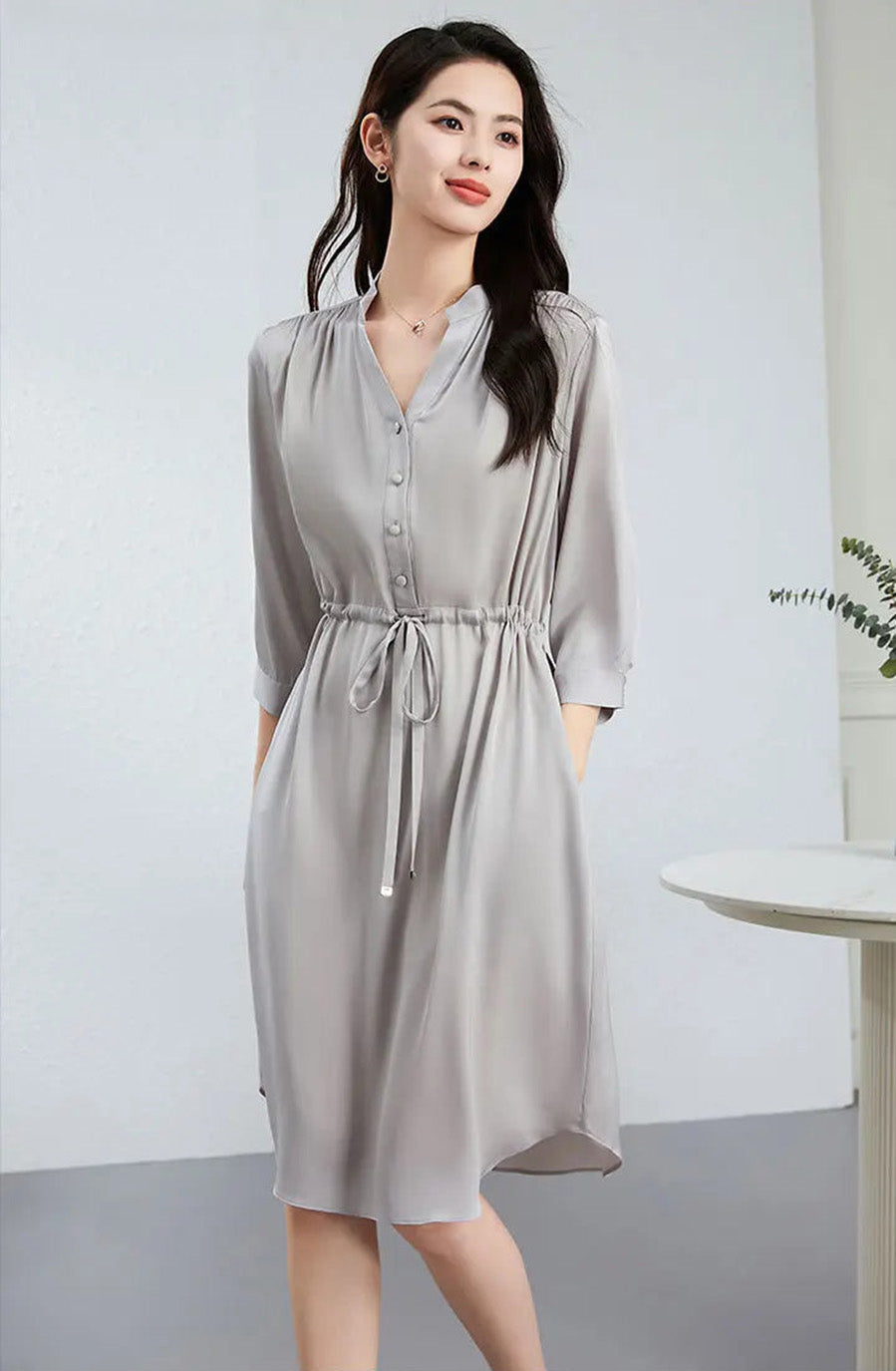 Side view of a woman walking in a light silk dress, showcasing the movement of the high-low hem and fluid draping. — From Borcelleclothes.