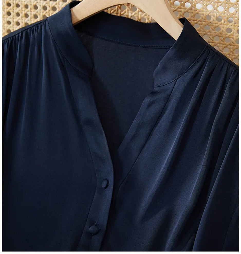 Detailed view of the narrow stand-up collar and the refined V-neckline placket with silk-covered buttons. — From Borcelleclothes.