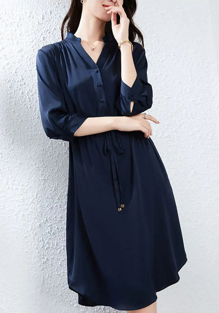 A thoughtful portrait of a woman in a silk dress with a V-neckline, capturing a moment of quiet reflection. — From Borcelleclothes.