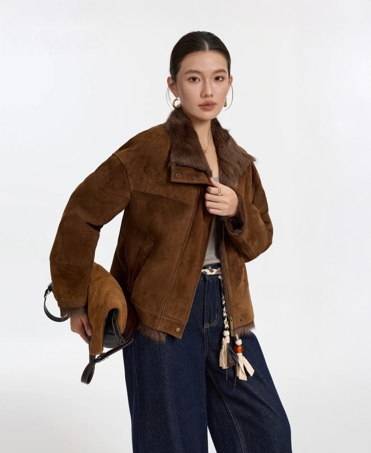 Model wearing Dark Rum goatskin jacket, unfastened, holding front edges — From Borcelleclothes.