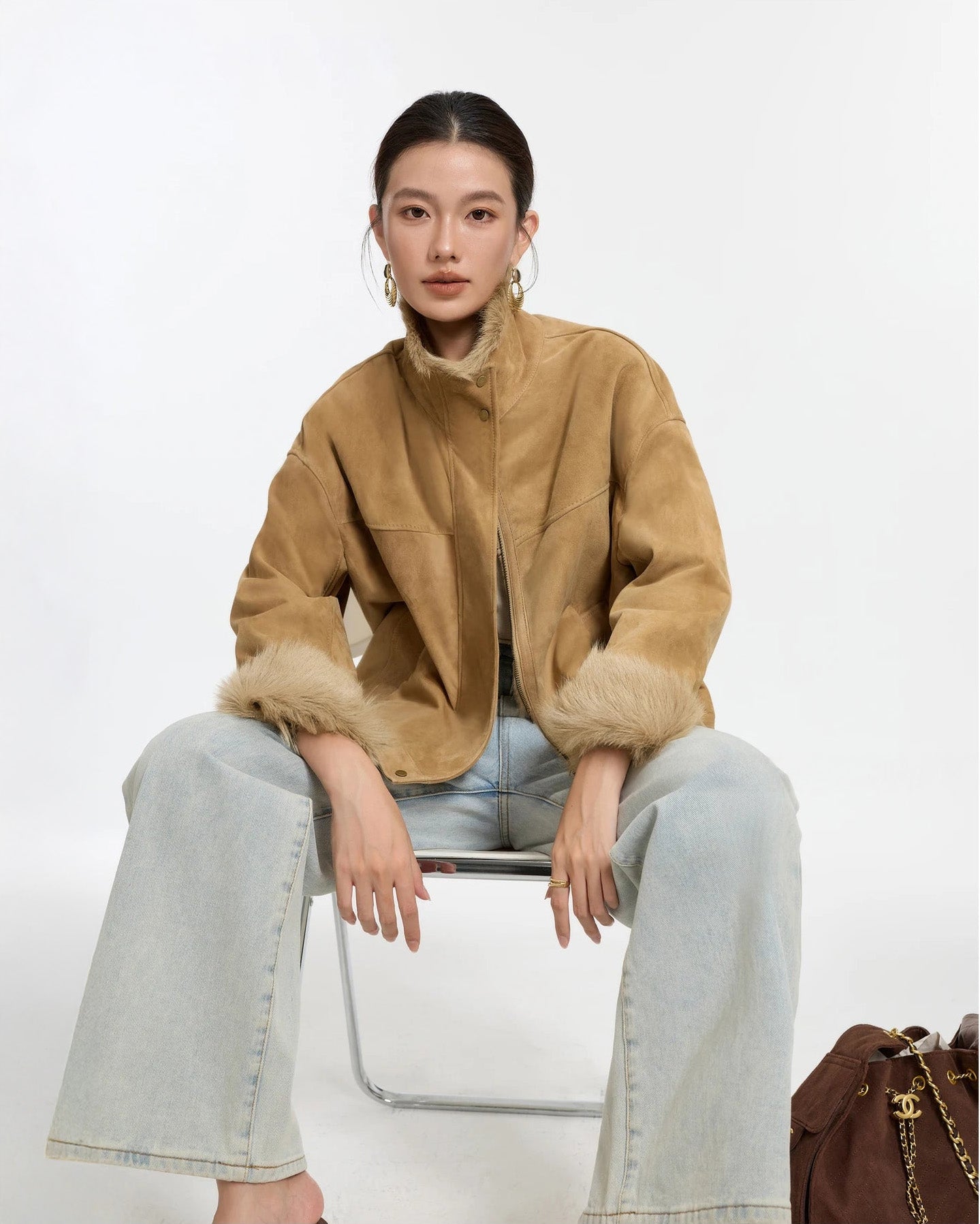 Model sitting in chair wearing Goatskin jacket in Late Wheat — From Borcelleclothes.