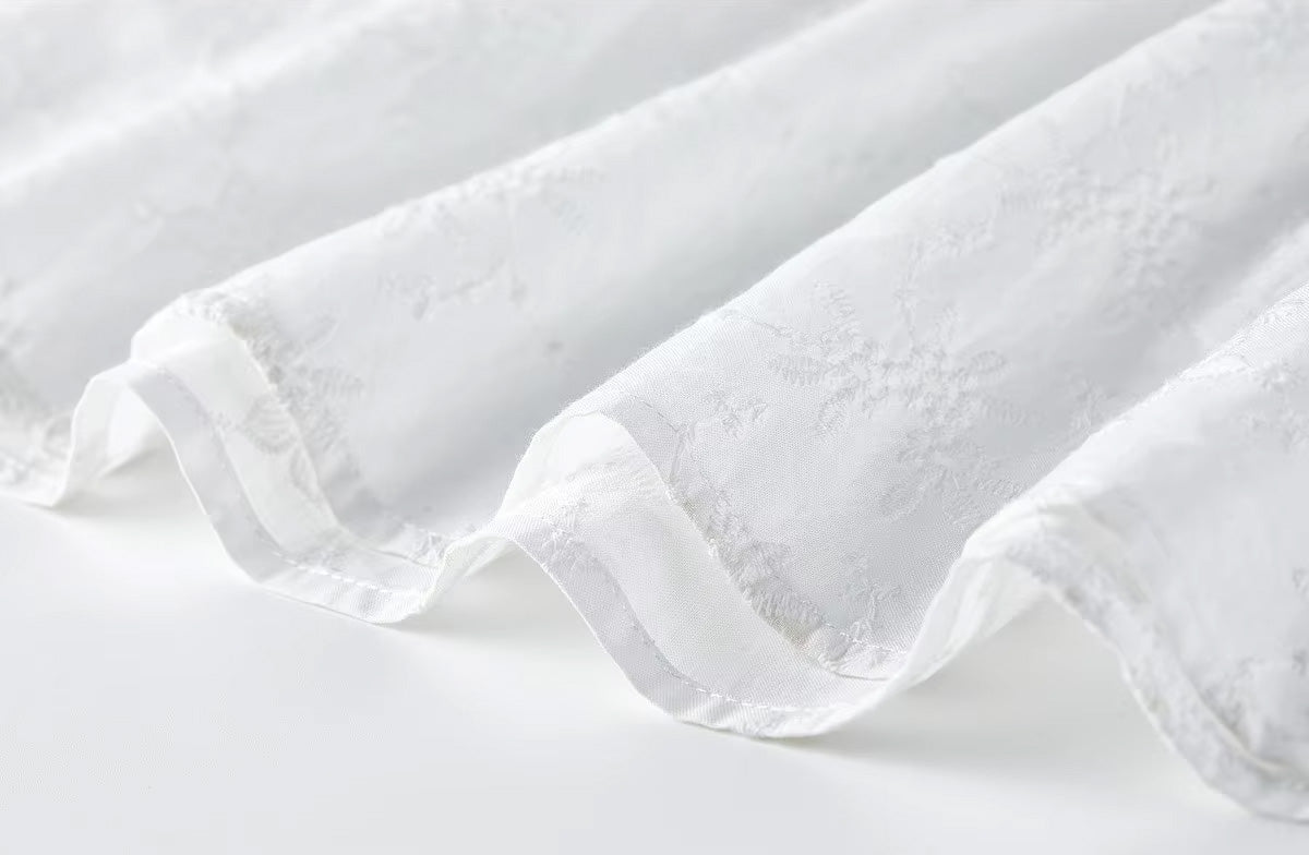 Macro shot of the clean, high-quality stitching and detailed scalloped embroidery along the bottom hemline — From Borcelleclothes.