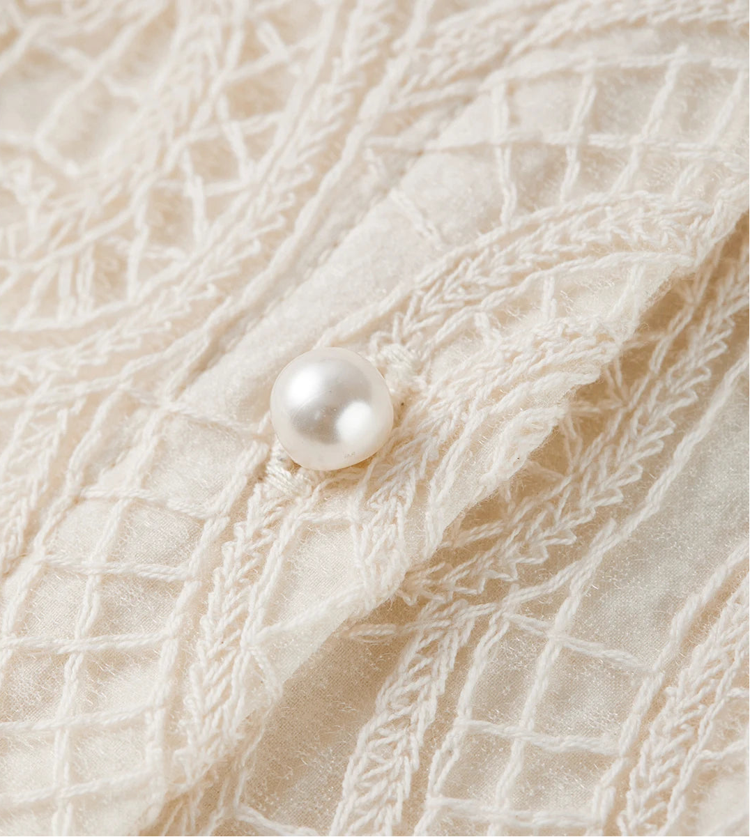 Macro shot of a delicate small pearl button, the tactile anchor of the Memory Overload blouse. — From Borcelleclothes.