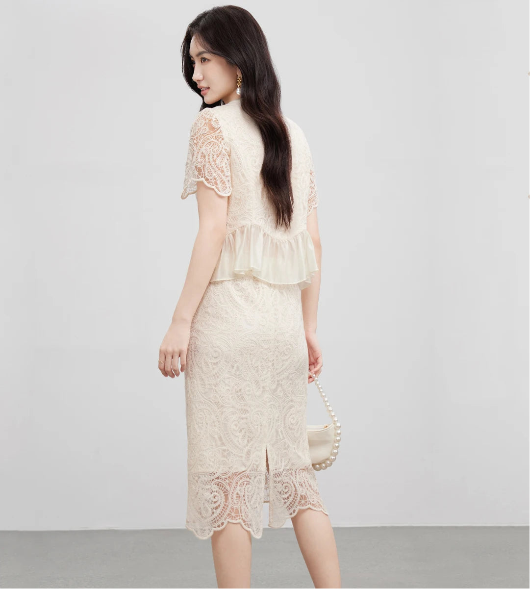 Rear view of the set, showing the clean lines of the pencil skirt and the soft drape of the lyocell peplum. — From Borcelleclothes.