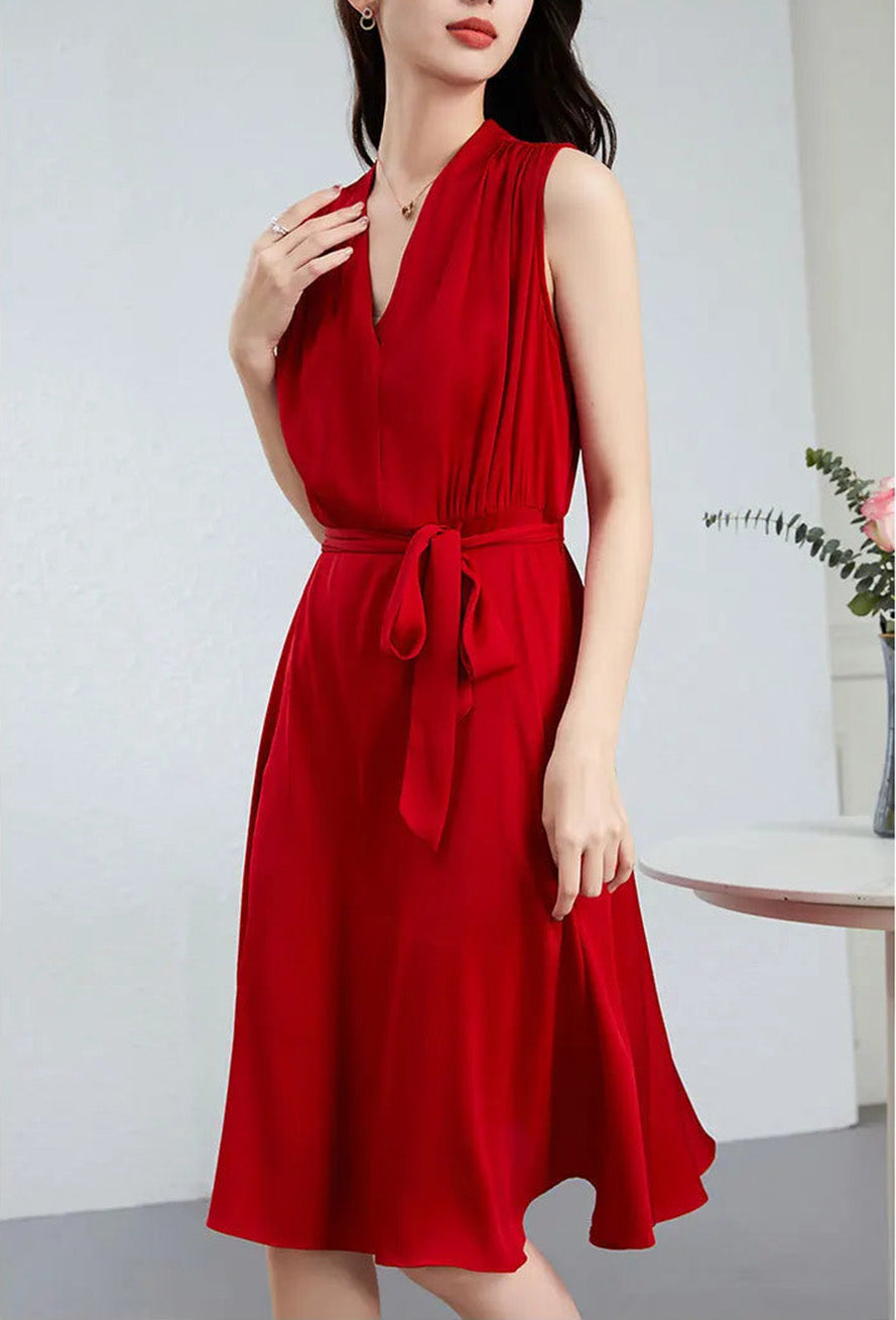 The model’s hand rests on the structured collar of her Monte Carlo silk dress, showcasing the fixed wrap bodice — From Borcelleclothes.