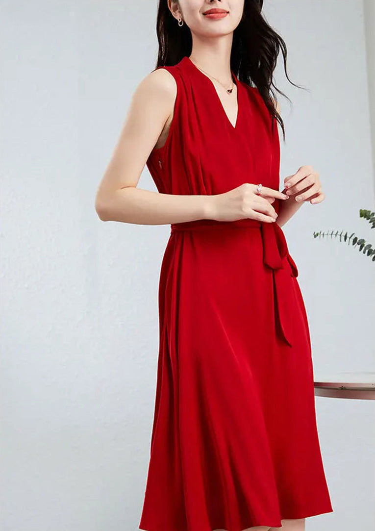 A graceful gesture of a woman in a red silk dress, drawing attention to the sculptural peripheral draping at the waist — From Borcelleclothes.