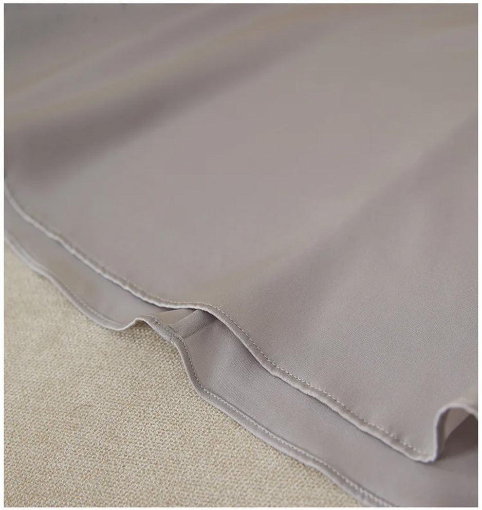 The clean finished bottom hem of the flared midi-length silk dress — From Borcelleclothes.