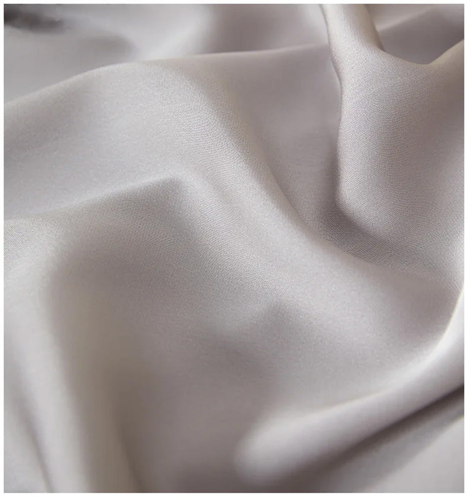 Macrophotography of the 19-momme silk double georgette texture, showing the noble wave-like folds of the fabric — From Borcelleclothes.