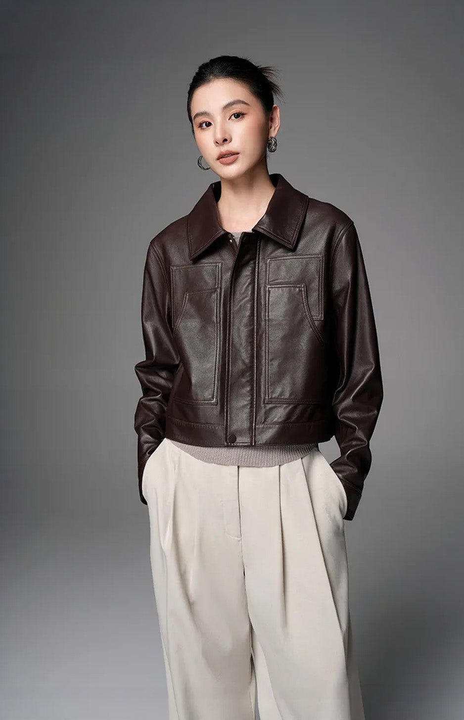 Front view of the model wearing the Rich Juniper cropped leather jacket with hands in trouser pockets — From Borcelleclothes.
