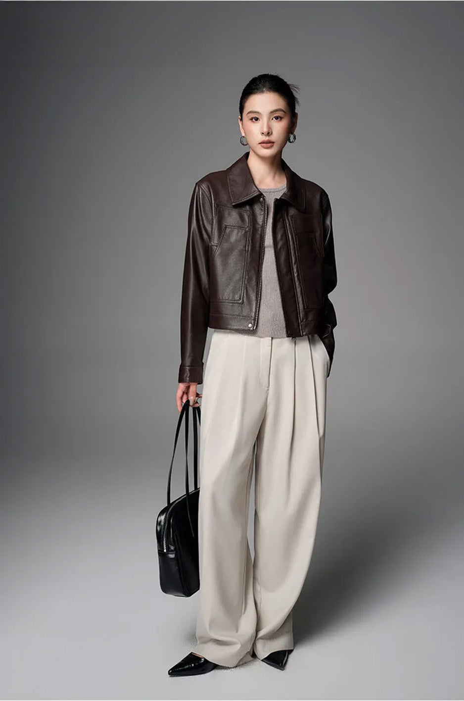 Model styled in the Rich Juniper cropped leather jacket holding an oversized bag — From Borcelleclothes.