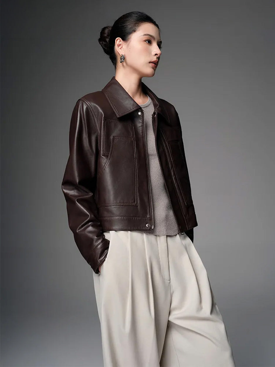 Model wearing the cropped fine-grain sheepskin jacket in Rich Juniper, turned slightly to the side — From Borcelleclothes.