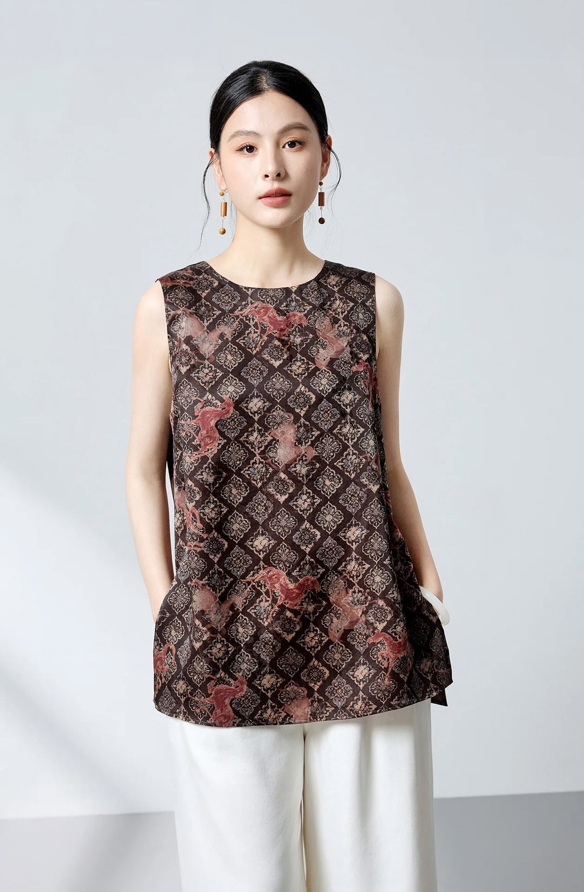 Portrait of the model looking directly into the camera wearing the artisanal Fire Steeds silk top — From Borcelleclothes.