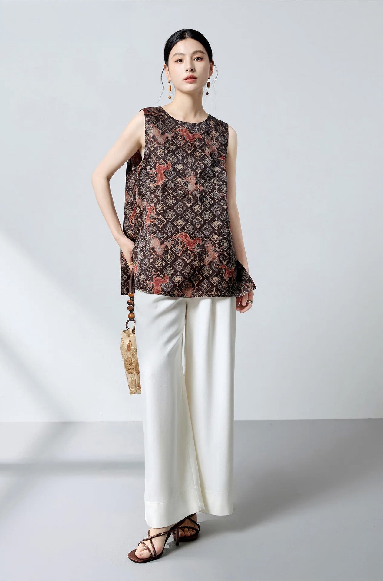 Full-length view of the model posing with one foot aside in the Fire Steeds silk jacquard top and trousers — From Borcelleclothes.
