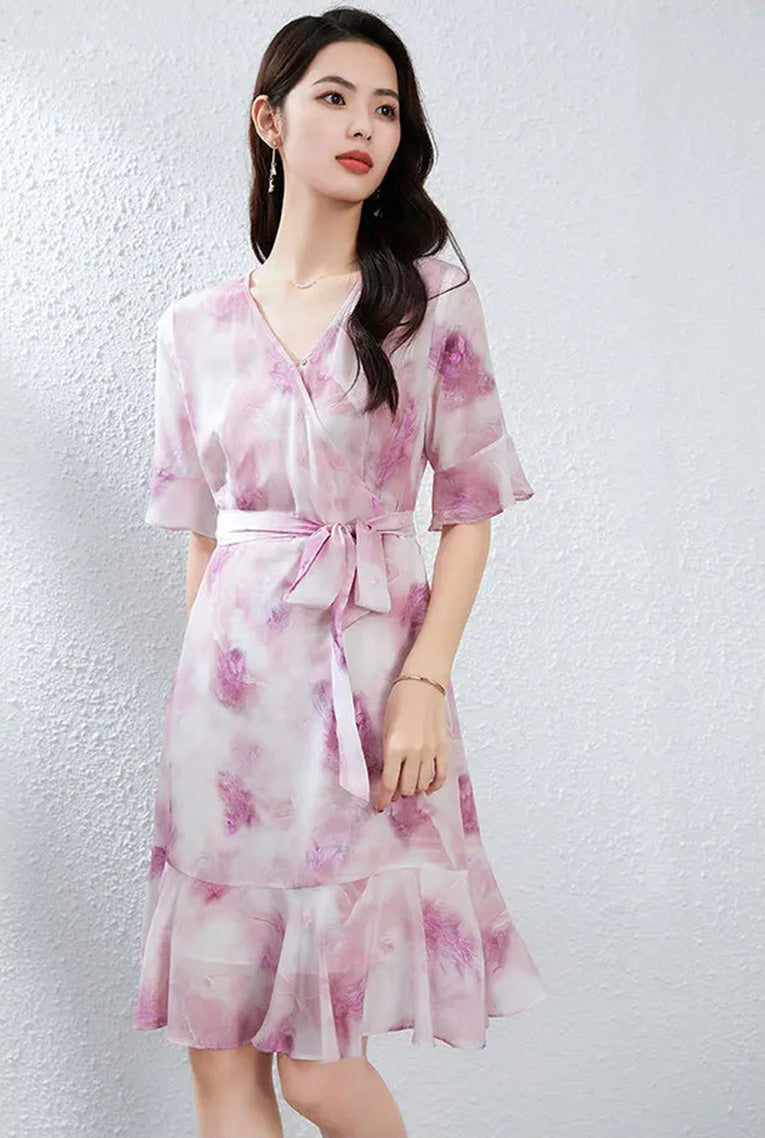 Side profile of a woman turned slightly, showcasing the fluid drape and elegant midi silhouette of the heather-purple silk dress — From Borcelleclothes.