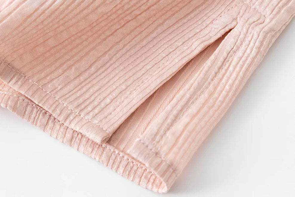 Hem side slit detail on pink fluted jacquard silk blouse by Borcelleclothes.