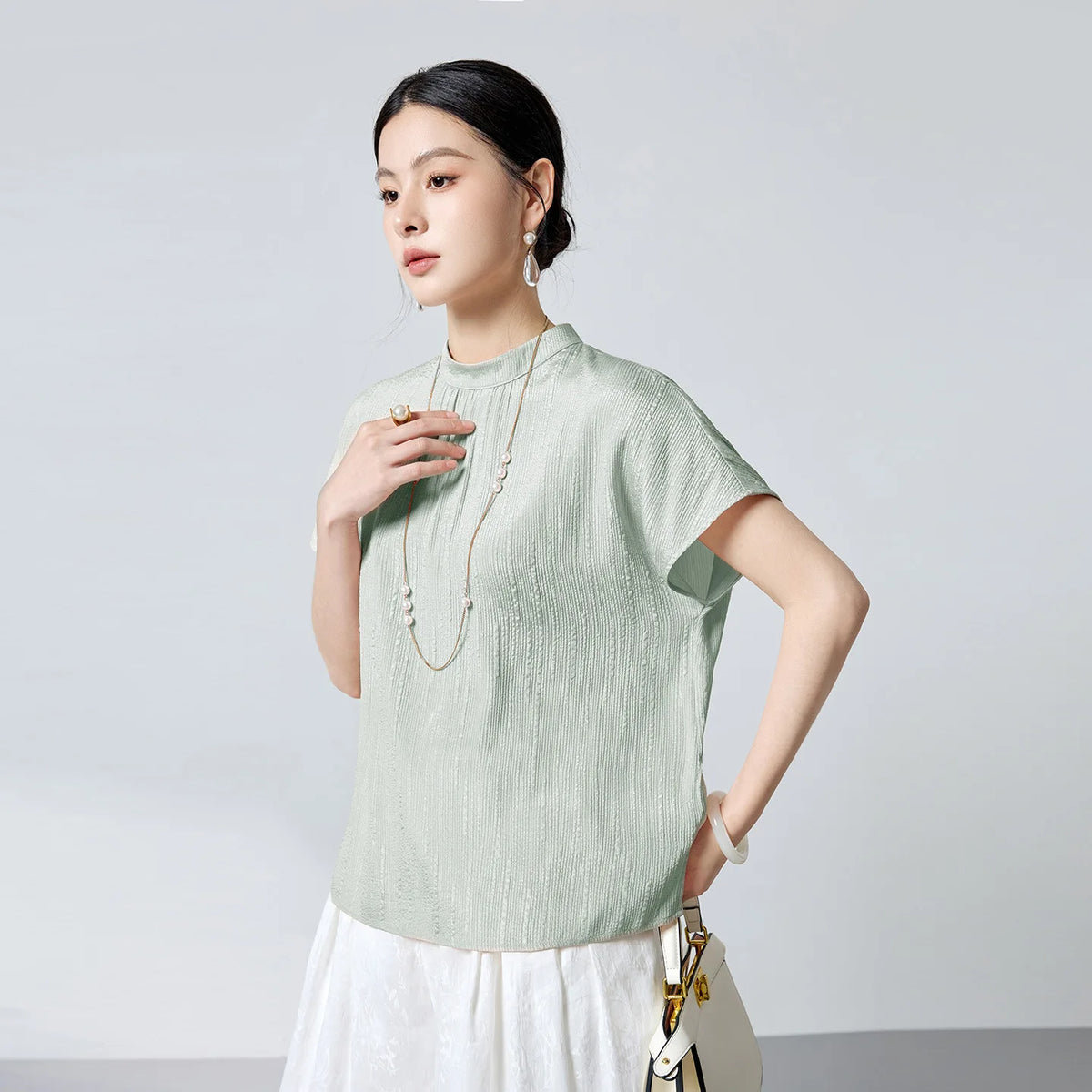 Women's 19 Momme stretch silk jacquard blouse in Mint Downpour. Features fluted texture, delicate gathers beneath a stand collar, and short kimono sleeves. — From Borcelleclothes.