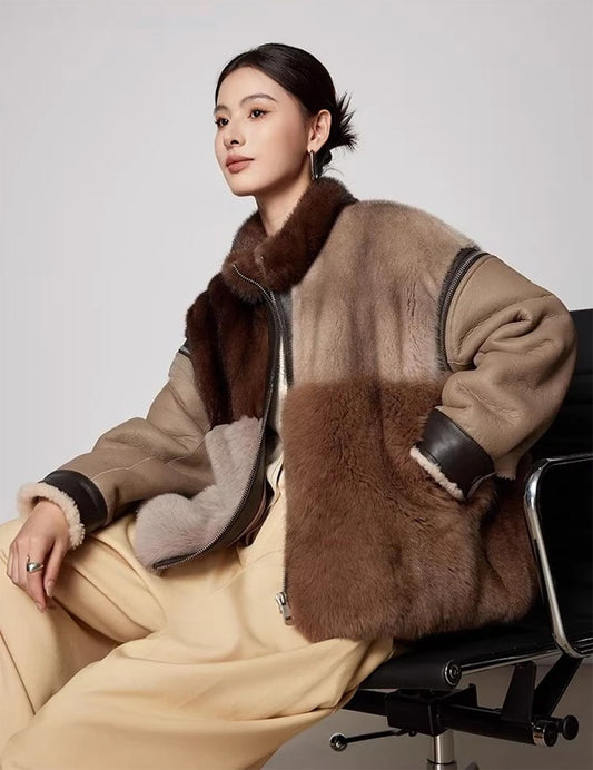 Model sitting in chair wearing women’s mink and fox fur jacket with chessboard panel layout and detachable shearling sleeves. — From Borcelleclothes.