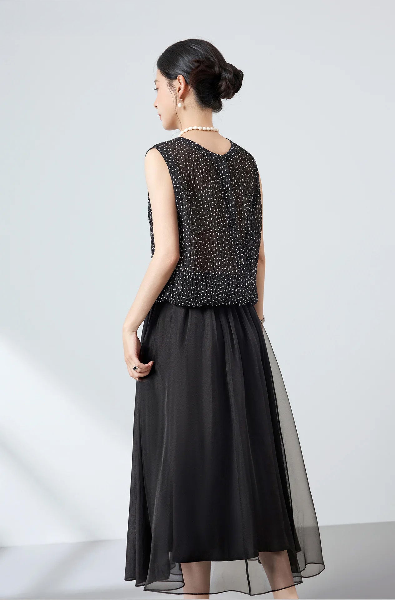 Back view of black polka dot silk blouse worn with mother-of-pearl buttons in the front — From Borcelleclothes.