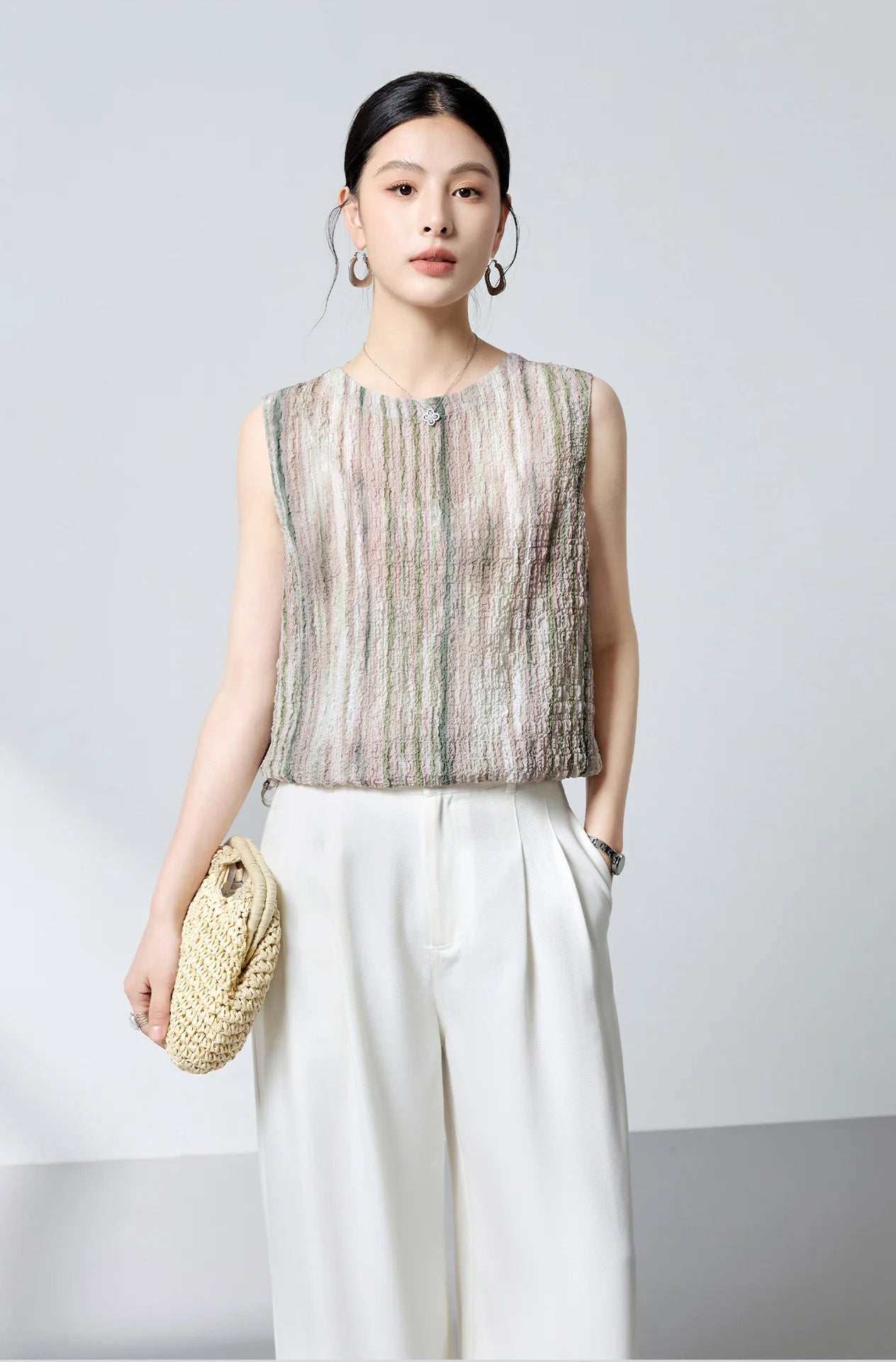 Full-length view of model with hand in pocket wearing silk blouse with buttons forward and wide-leg trousers — From Borcelleclothes.