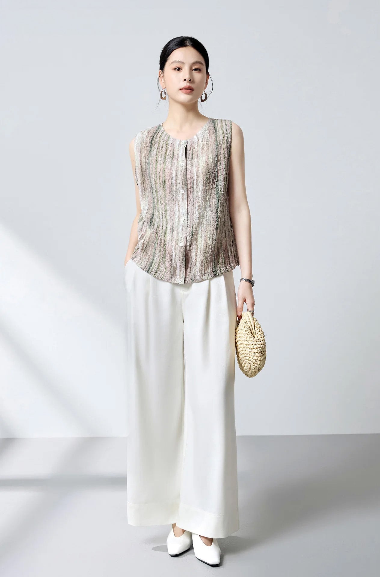 Full-length styling of sleeveless Mulberry silk blouse with adjustable drawstring hem and woven clutch — From Borcelleclothes.