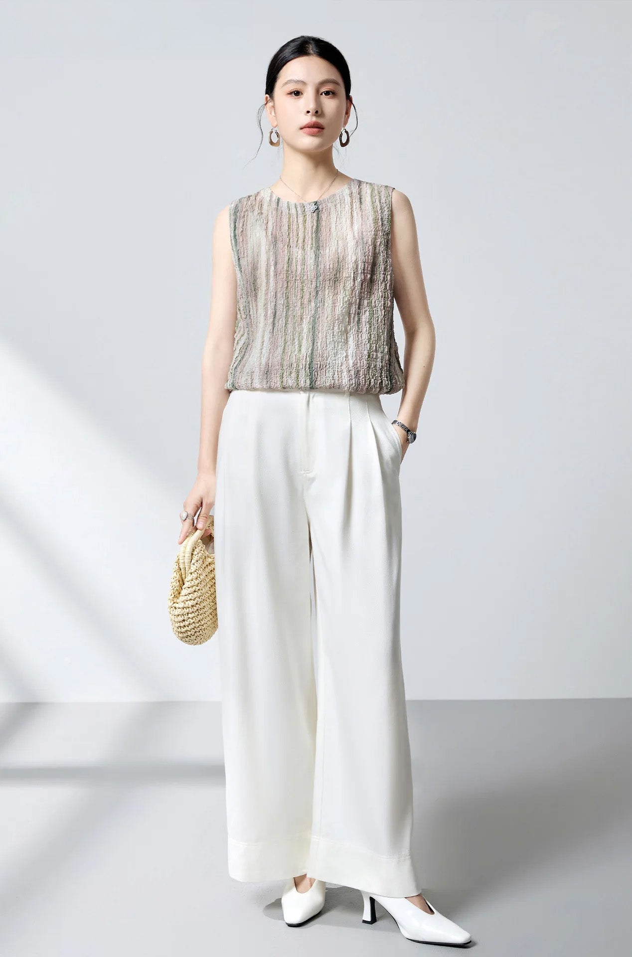 Studio portrait of model wearing front-to-back sleeveless silk blouse with front button placket — From Borcelleclothes.