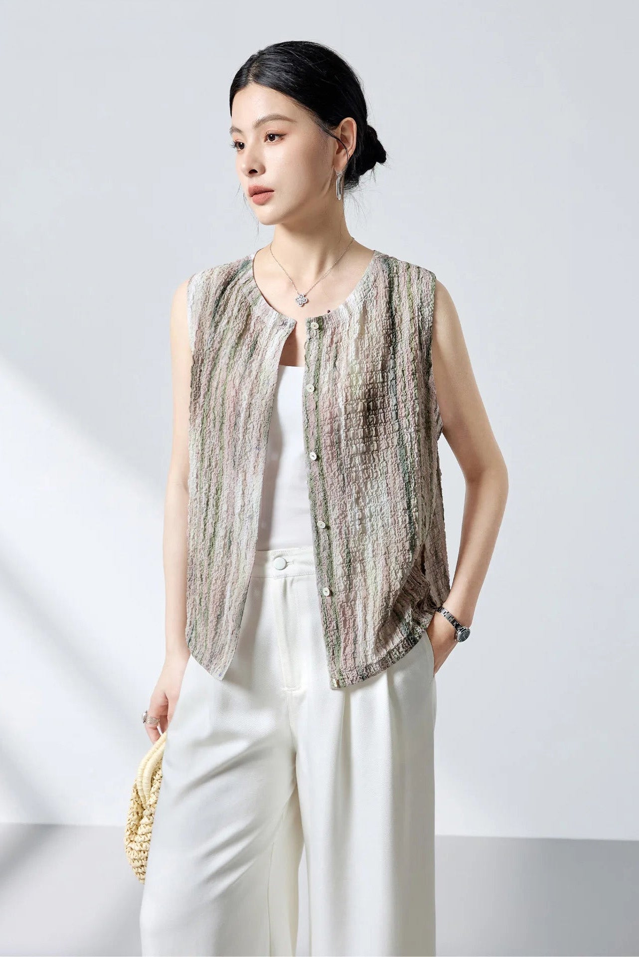 Side profile of model wearing unbuttoned 3D puckered jacquard silk blouse in Promesse de l’Aube — From Borcelleclothes.