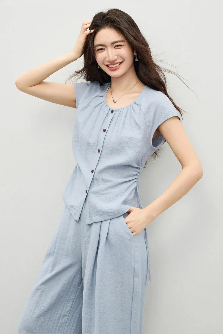 A radiant woman in the Bleu Soleil set, the vibrant blue hue complementing the natural crinkled texture of the fabric. — From Borcelleclothes.