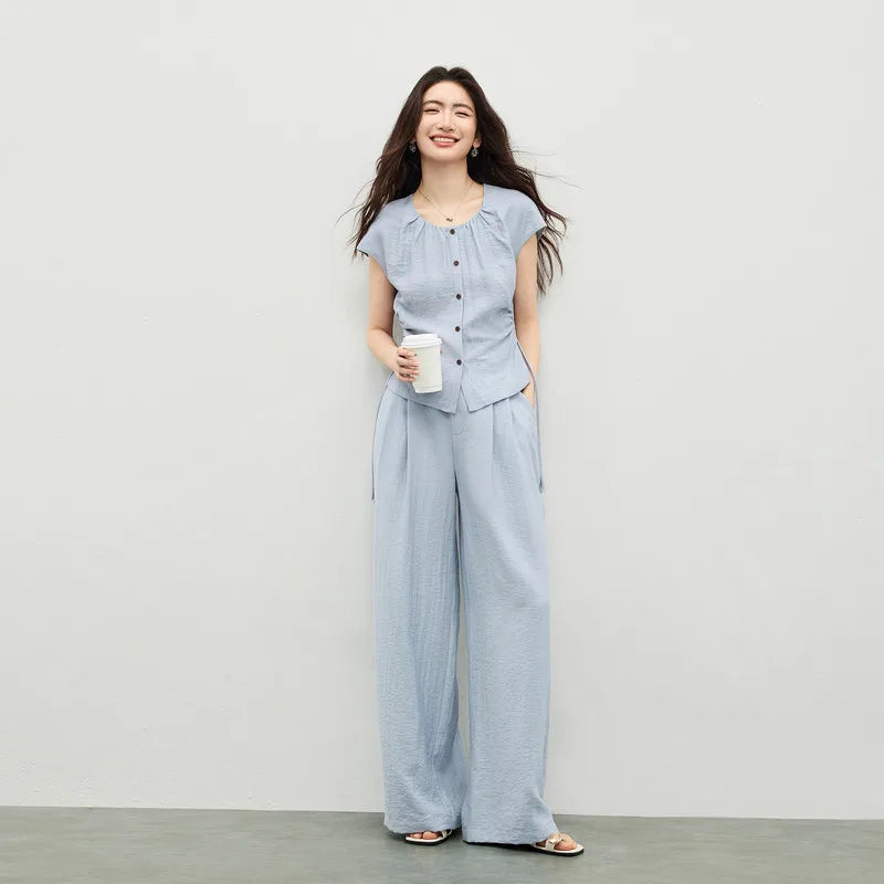 Women's blue set in crinkled fabric, showing a sleeveless top with a gathered neck and drawstring waist, and matching wide-leg pants. — From Borcelleclothes.