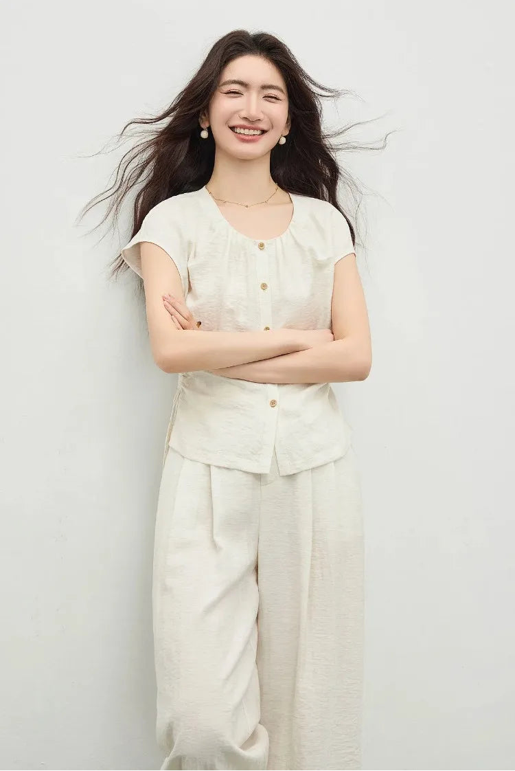 A woman standing with crossed arms, showcasing the relaxed dropped shoulder silhouette and the structure of the vest. — From Borcelleclothes.